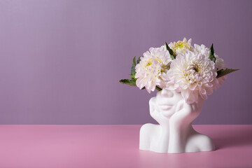 Plaster head with flowers on a colored background. Mental health concept. Copy space