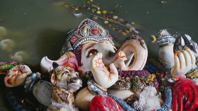 ganesh statue close up shot in the lake with water after visarjan
