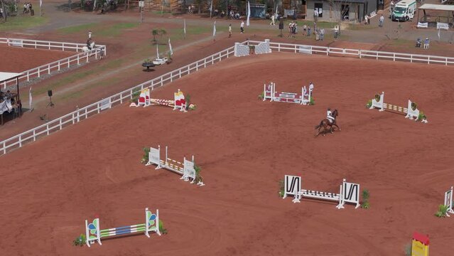 Horse rider performing jumps in the horse jumping barn Aerial View of Thrilling Horse Jumping Event 