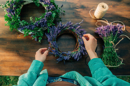 Hand of woman making lavender wreath on table