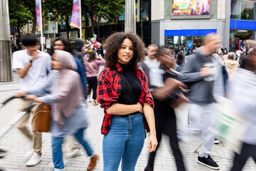 Smiling woman standing amidst crowd in city