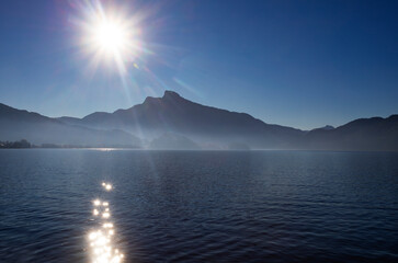 Austria, Upper Austria, Sun rising over Mondsee lake with Schafberg mountain in background