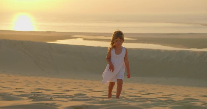Free girl walking fun across the sand field on the coast ocean. Dream concept