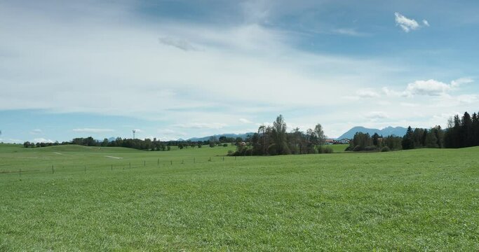 Near Sachsenkam south of Munich along the roads of Kirchsee and Stubenbach with view on green meadows and hills around  Reutberg monastery and brewery and Bavarian Alps on the horizon