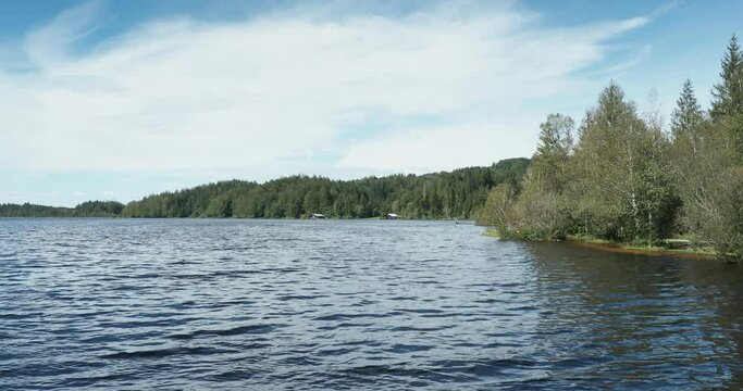 Kirchsee in Upper Bavaria. The bank of the lake with calm waters along the Zeller Forest with view on one large bathing jetty,  fishermen's huts and lifeguard station