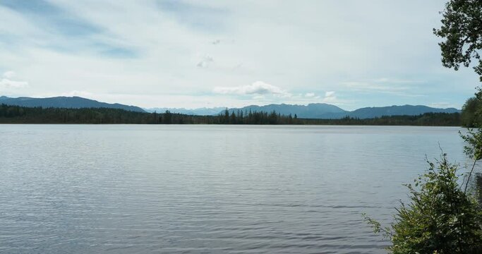 Kirchsee, bog lake near Sachsenkam in Upper Bavaria with view from North bank on its calm waters and highest peaks of Wetterstein mountains along Austria&ndash;Germany border