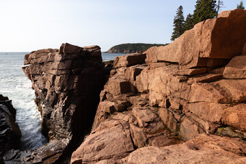 High angle horizontal view of the cliffs towering over Thunder Hole seen during an early sunny morning, Acadia National Park, Mount Desert Island, Maine, USA
