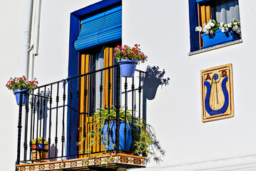 Typical white facades with flowers on the balconies of the streets of the famous Peñiscola castle,...