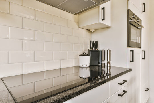 Kitchen with black countertop and white backsplash tiles