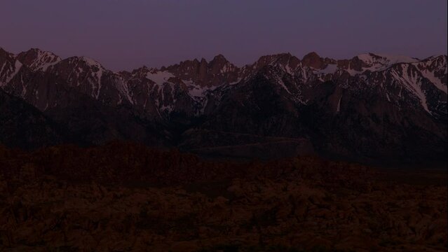 Timelapse of sunrise illuminating Mt. Whitney in Sierra Nevada mountains in Alabama Hills in California, USA
