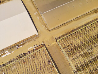 Factory under construction. Aerial drone photo of a factory being built by workers on the edge of...