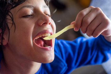 happy boy eating noodles with long hands - obrazy, fototapety, plakaty