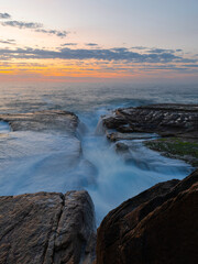High tide water flowing into rock platform on the shore.
