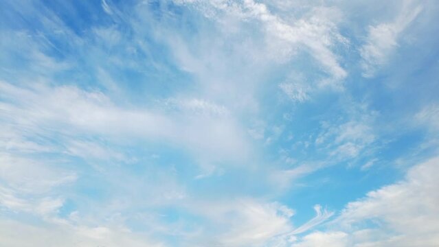 Wispy clouds moving in the blue sky during bright sunny summer day, timelapse