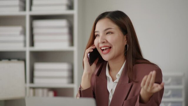 Businesswoman in brown suit is talking to clients and colleague on the phone.