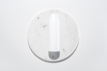 Face cleanser foam in light plastic bottle on marble circle white background. Clean minimalist high key skincare product shot top view