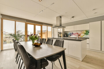 Dining area with chairs around table by kitchen at home