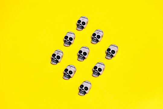 Set of illustrated skull composing rhomb on yellow backdrop