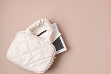 Beige quilted puffed bag on pastel background. Stylish woman handbag. Winter fashion accessories