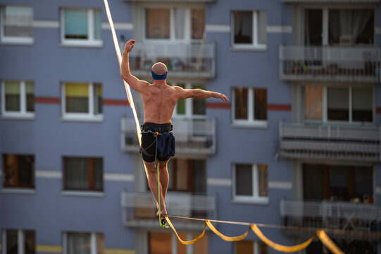 a man tightrope high between buildings