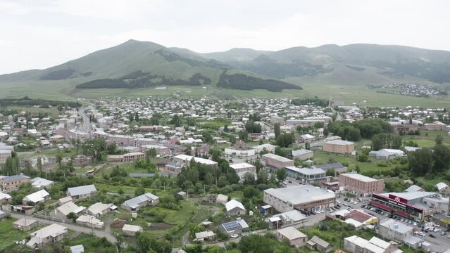 Aerial view city town with mountains background.  Drone view Aparan town, Armenia, Caucasus. Small houses, building on mountain background. 