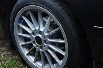 old black car in the yard wheels titanium rims long exposure video on dark background spinning