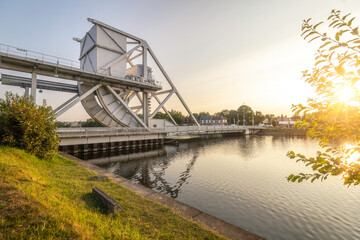 Le célèbre pont Pegasus bridge dans le calvados en Normandie au dessus du canal de Caen , lieu iconique de la seconde guerre mondiale, débarquement du 6 juin 1944. Vue de coté avec un soleil lumineux. - obrazy, fototapety, plakaty