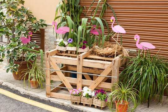 Wooden box, decorated with some pink flamingos and flower pots on "Costitx en Flor" (Costitx in bloom) Flower Fair, Majorca, Spain