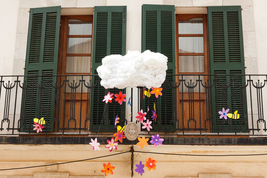 Doors with green shutters, decorated with a cloud and some flowers on "Costitx en Flor" (Costitx in bloom) Flower Fair, Majorca, Spain