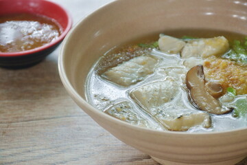 boiled rice with bass fish and mushroom in clear soup on bowl dipping spicy sauce