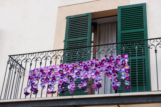 Balcony with green shutters, decorated with violet crochet flowers on "Costitx en Flor" (Costitx in bloom) Flower Fair, Majorca, Spain
