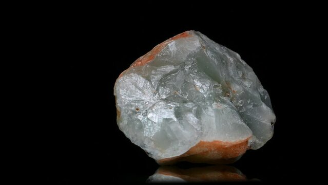 Prehnite (inosilicate of calcium and aluminium with the formula Ca2Al2) nodule rotating slowly against a black background.