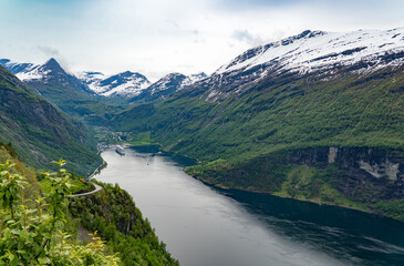Beautiful view of the Geiranger Fjord and the town of Geiranger from the Adlerkehre with a cruise ship at anchor - 657081603