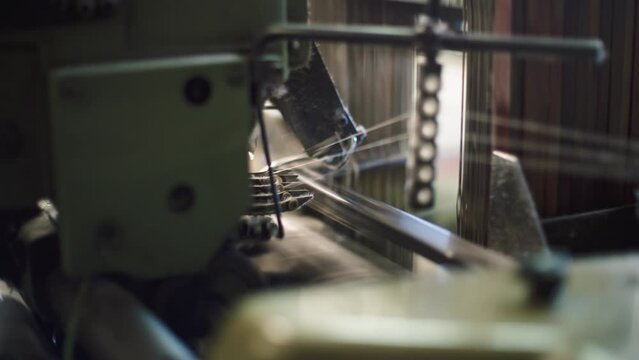 Close-up of a weaving machine in operation. French industry.