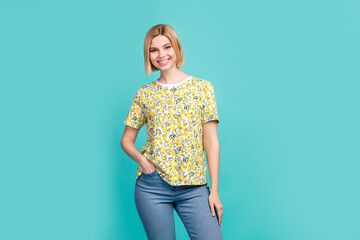 Photo of adorable cheerful girl dressed yellow print t-shirt smiling walking isolated teal color background