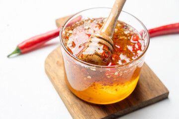 Spicy honey with hot chili pepper close-up.