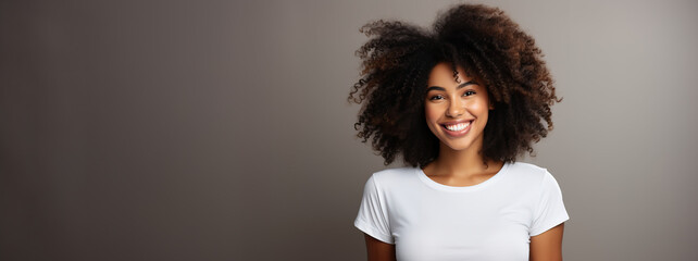 Studio portrait of smiling afro young college woman wearing white t-shirt - obrazy, fototapety, plakaty