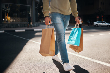 Man, legs and shopping bags in street of city, pedestrian or crosswalk for travel, shop or mall....