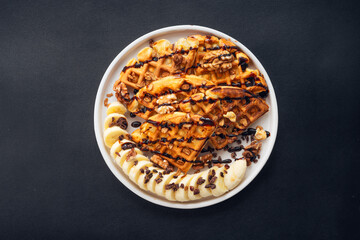 Waffle, banana, chocolate topped with walnuts