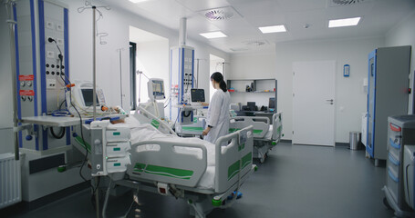 Emergency room with modern equipment in hospital. Elderly man in oxygen mask lies and sleeps in bed...