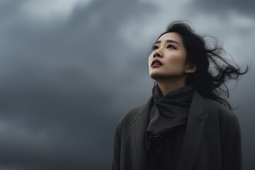 Fototapeta premium Asian woman looking up cloudy sky