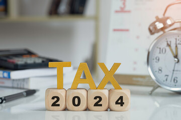 Tax and Vat 2024 Concept.Tax wooden letters on wooden cubes with 2024 on coins. income tax online...