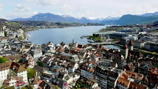 panoramic aerial view of the city of Lucerne and Lake Vierwaldstättersee with surrounding peaks in the Alps of Switzerland featuring Seebrücke, Kapellbrücke, Reuss River, and Torbogen Luzern 
