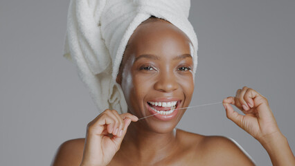 Portrait, beauty and dental floss with a happy black woman in studio on a gray background for...