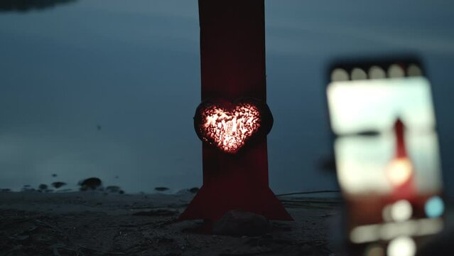 People at dusk by the lake launch festive rockets. Romantic evening.