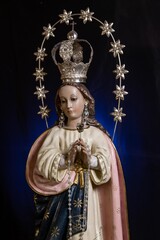 Fototapeta na wymiar Statue of the Virgin of Fatima on an altar with dark background