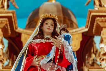 Statue of the Virgin of Rosario on an altar with church background