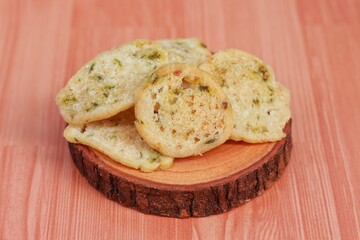 Basreng, Indonesian traditional chip made from fried meatball with chilli powder and lime leaves for seasoning served on wooden plate. Spicy Indonesian chip
