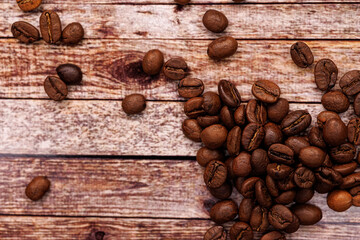 Arabica coffee beans are scattered across the table. Coffee beans on the table.