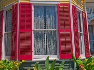 Bright red shutters from tall historic windows of house in Galveston Island, Texas